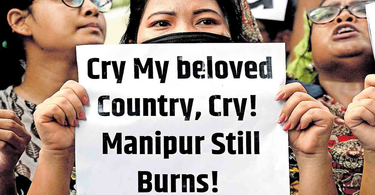 Protester holding a sign reading 'Cry My Beloved Country, Cry!' at a demonstration